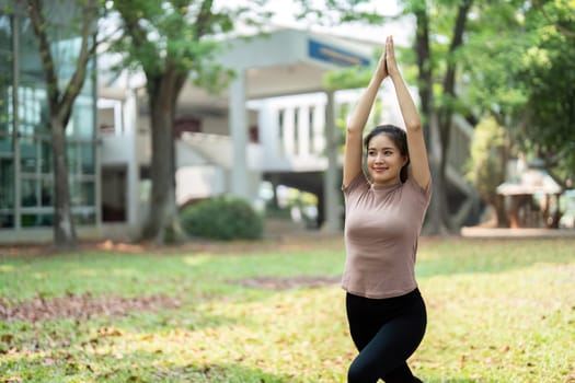 Focusing on her breath, a young woman performs yoga in a serene environment, incorporating nature into her exercise routine for holistic wellness.