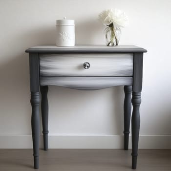 A beautifully painted table showcases a sleek design in a minimalist room. It features a single drawer and is accentuated by a delicate vase and white flower.