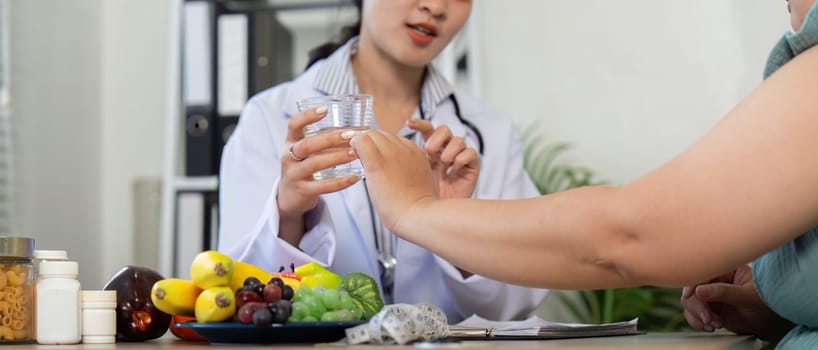 A healthcare professional engages with a patient, showcasing a variety of fresh fruits and emphasizing hydration with a glass of water. The session highlights the importance of nutrition and wellness.