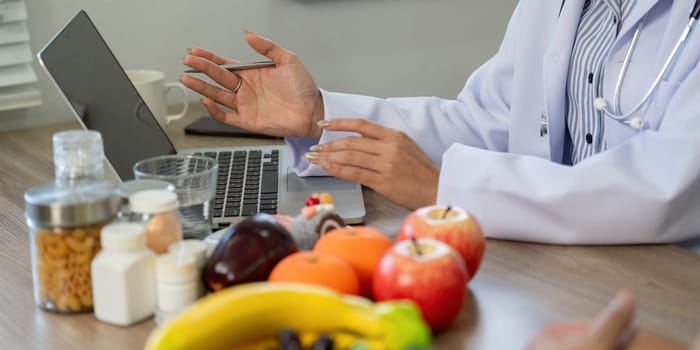 A medical professional shares insights on nutrition while using fruits as visual aids to enhance understanding during a consultation.