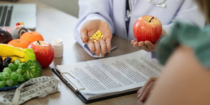 In a consultative setting, a healthcare professional compares healthy food choices with dietary supplements, guiding the patient towards informed decisions.
