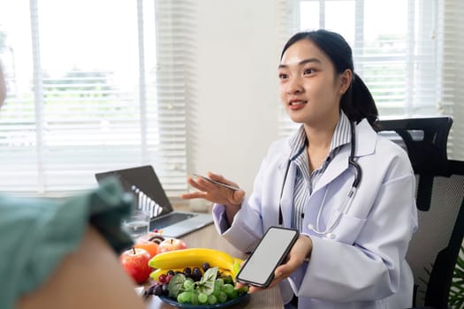 During a nutritional consultation, a healthcare professional explains dietary options using a smartphone, highlighting the importance of technology in promoting wellness.