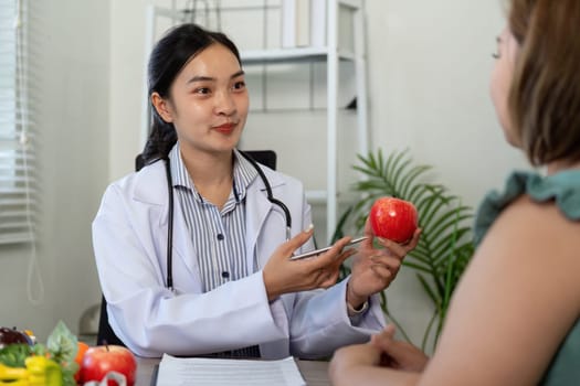 In a friendly consultation, a healthcare professional discusses the nutritional benefits of apples to encourage healthier habits in her patient.