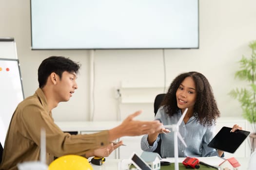 In a modern workspace, two professionals engage in meaningful dialogue about innovative renewable designs, emphasizing teamwork in sustainable solutions.