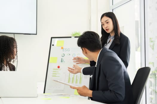 In a focused meeting, a team member presents ESG metrics, fostering informed decision-making towards sustainability.