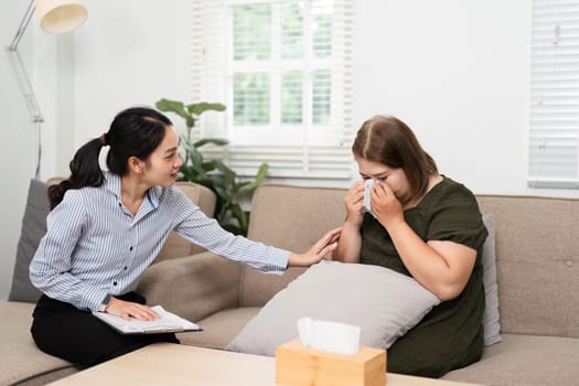With a gentle touch, a psychiatrist reassures her patient who is visibly distressed, creating a nurturing therapeutic environment during a crucial session.