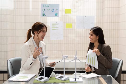 Two women in a meeting enjoy a fruitful conversation about sustainable business practices, emphasizing the importance of ESG initiatives and teamwork in achieving their goals.