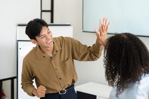 A moment of connection as two professionals celebrate their collaboration efforts in renewable energy with high fives.