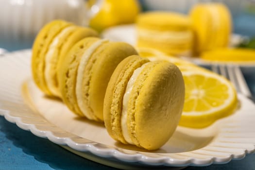Delightful yellow lemon macarons, filled with creamy white goodness, beautifully arranged on a white plate alongside fresh lemon slices