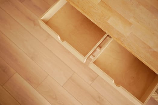 Two wooden drawers remain open in a simple, minimalist interior design.