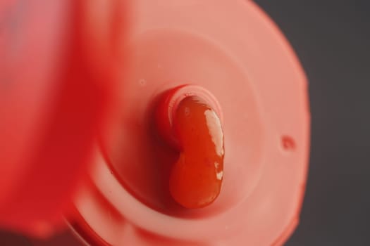 A smooth dollop of bright red sauce rests on a bottle cap.