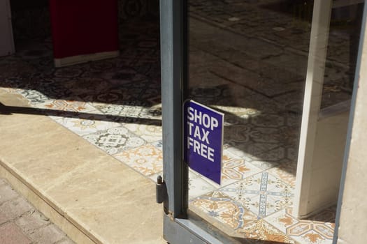 A sign promotes tax-free shopping in a charming retail area.