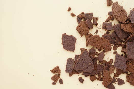 Crumbled chocolate cake pieces create a textured layout on a backdrop.