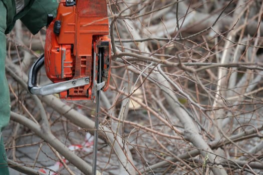 A worker removes debris using a chainsaw during a cleanup effort.
