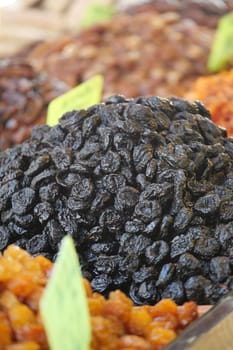 A colorful assortment of dried fruits, featuring dark raisins, is showcased.