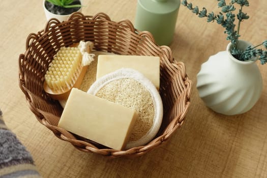 Natural bath products arranged in a woven basket on a wooden surface.