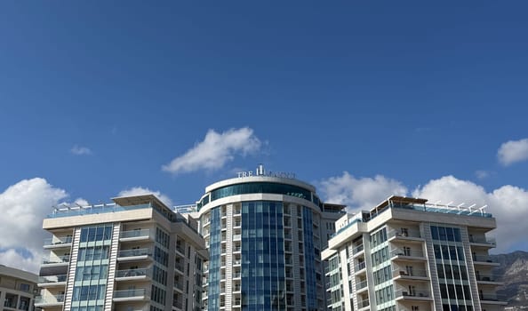 Budva,Montenegro-April 11,2025:Elegant high rise buildings of the TRE CANNE hotel with glass facades and balconies, with signage and clear sky in the background.