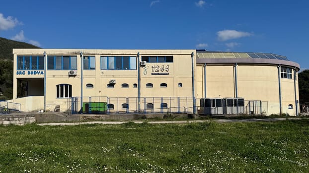 Budva, Montenegro - April 11, 2025: building branded by 1244 ,,Health Performance,, filmed on a sunny day with blue windows and grassy foreground. High quality photos