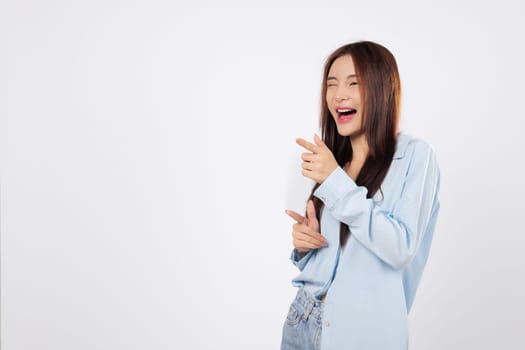 With gesture of what up, woman smiles and points finger like a gun, while another woman gives cheeky expression full of confidence, standing against isolated white background.