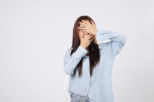 Covering face with hands, afraid woman shows panic while another woman peeks through fingers with fearful eyes, capturing raw emotion isolated on white background.