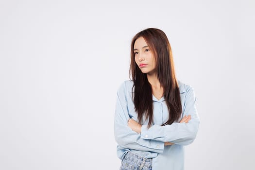 Crossed arms on angry woman, unhappy woman yells in fury, showing frustration and rage in a dramatic pose on isolated white studio background with empty space. Asian