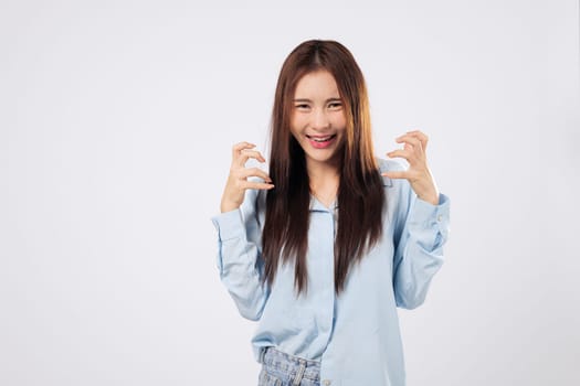 Asian happy portrait beautiful cute young woman standing angry and mad raising fist frustrated and furious while shouting with anger isolated, studio shot on white background and copy space