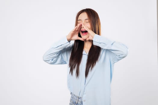 Loud advice from woman with eyes closed, second woman cups hands to mouth, sharing news in a hushed yet energetic way, isolated against white background. Shouting