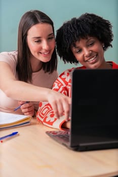 Caucasian and African American students work together using a laptop and notebook.Focused and cheerful, they collaborate in a cozy indoor space,representing learning, diversity, and teamwork. Vertical