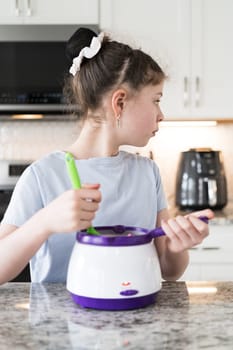 With focused attention, this budding culinary artist dips pretzels into a pot of melted chocolate, creating sweet delights in the warmth of a well-lit home kitchen.