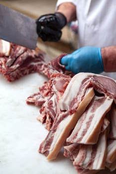 Butcher cutting pork chops on a stall