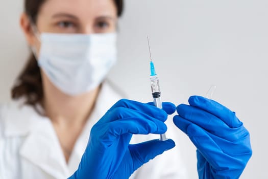 The concept of the new coronavirus COVID-19,2019-nCoV. Syringe with a vaccine in a doctor's hand, close-up