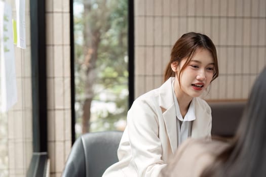 A constructive dialogue focuses on sustainable practices as two women professionals plan their approaches in a bright and inviting office space