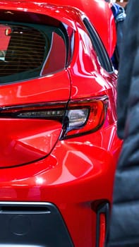 The car is clean and has a modern design, showcasing sleek lines and a shiny exterior. It is parked in a spacious parking lot and the keys are conveniently left in the ignition for easy access.