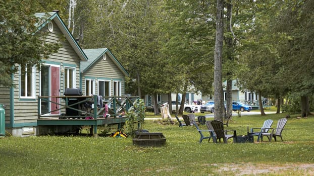 Ottawa, ON Canada - 07.07.2024: Charming Small Wooden Cottages Nestled in a Lush Green Forest Surrounded by Nature s Beauty.