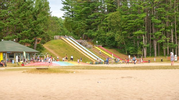 Ottawa, ON Canada - 07.07.2024: Playground equipment on a sandy beach with a forest in the background.