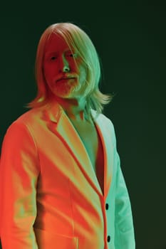 This image features a fashionable man with long, flowing blonde hair in a contemporary outfit The bold green and red lights create a striking visual impact, enhancing the overall aesthetic The dark background contrasts with the vivid colors, making the subject stand out prominently