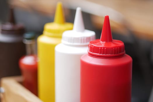 Condiments in various colors are arranged neatly for serving food.