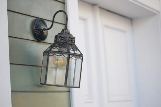 A decorative lantern illuminates the entrance to a home.