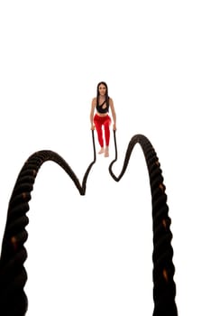 Full body of young female in trendy outfit standing on white background and looking at camera with pulling rope