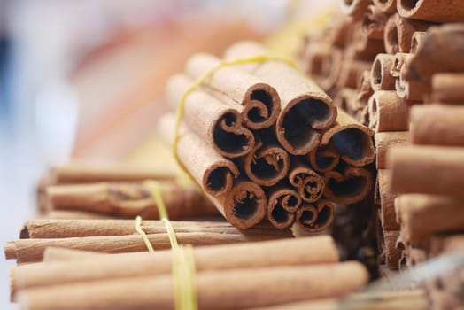 Bundles of fresh cinnamon sticks arranged for sale at a market.