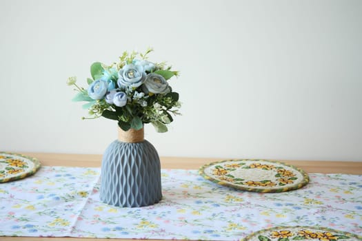 A beautiful bouquet of blue flowers in a stylish vase graces the table.