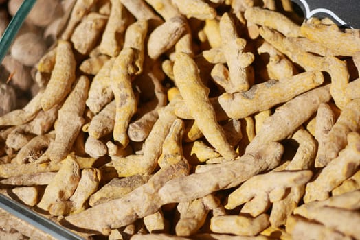 Vibrant turmeric roots are shown in a market, showcasing their earthy texture.