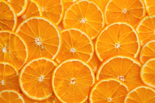 Bright orange slices are neatly arranged in a pattern, showcasing their juicy texture and vibrant color. Perfect for culinary presentations, drinks, or healthy snacks at any time.