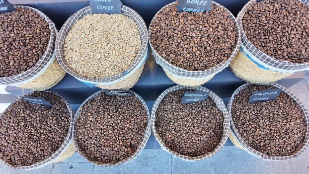 Multiple baskets filled with various coffee bean types showcased outdoors.