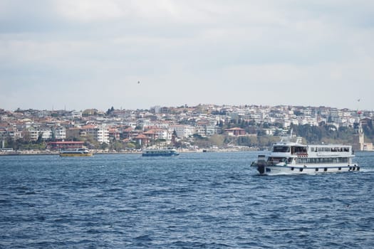 Ferry travels across the water with a vibrant cityscape nearby.