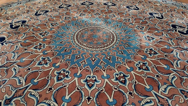 A beautifully crafted carpet showcases its elaborate design and colors.