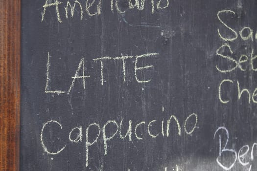 The menu displays popular coffee beverages written in chalk.