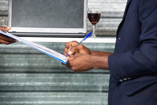 african american adult businessman hand putting signature on an official document
