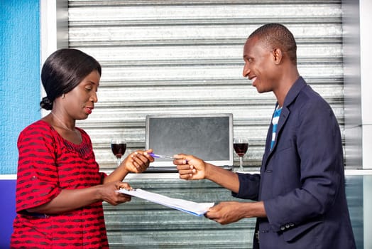 beautiful business women giving a pen to the businessman for signing the contract while being smiling in the street