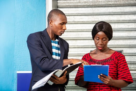 Boss commenting on the records of a personal assistant at hand and talking about the business plan in town.